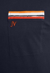 Marineblaues T-Shirt mit einer Brusttasche, die mehrfarbige Streifen (orange, weiß, rot, schwarz) aufweist, sowie einem kleinen orangefarbenen, gestickten Detail "JV".