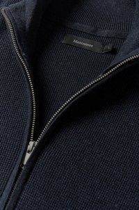 Pulover navy cu fermoar, cu textură ribbed, fermoar argintiu și eticheta "Matinique" în negru. Prezintă un guler înalt și un design cu tricotaj mediu.