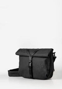 Borsa a tracolla nera realizzata in tessuto resistente, con chiusura roll-top, spallaccio regolabile e logo in rilievo sulla parte frontale.