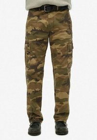 Pantalones cargo de camuflaje en tonos de marrón y verde. Presentan múltiples bolsillos, un diseño de pierna recta y una textura de tejido resistente.