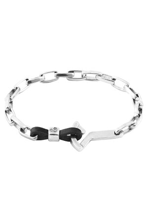 Silver chain bracelet featuring elongated links, a black leather bow accent, and a smooth metal clasp with detailing.