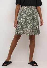 Gonna nera floreale con silhouette svasata, tessuto leggero, piccoli motivi a fiori bianchi e cintura elastica per il massimo comfort.