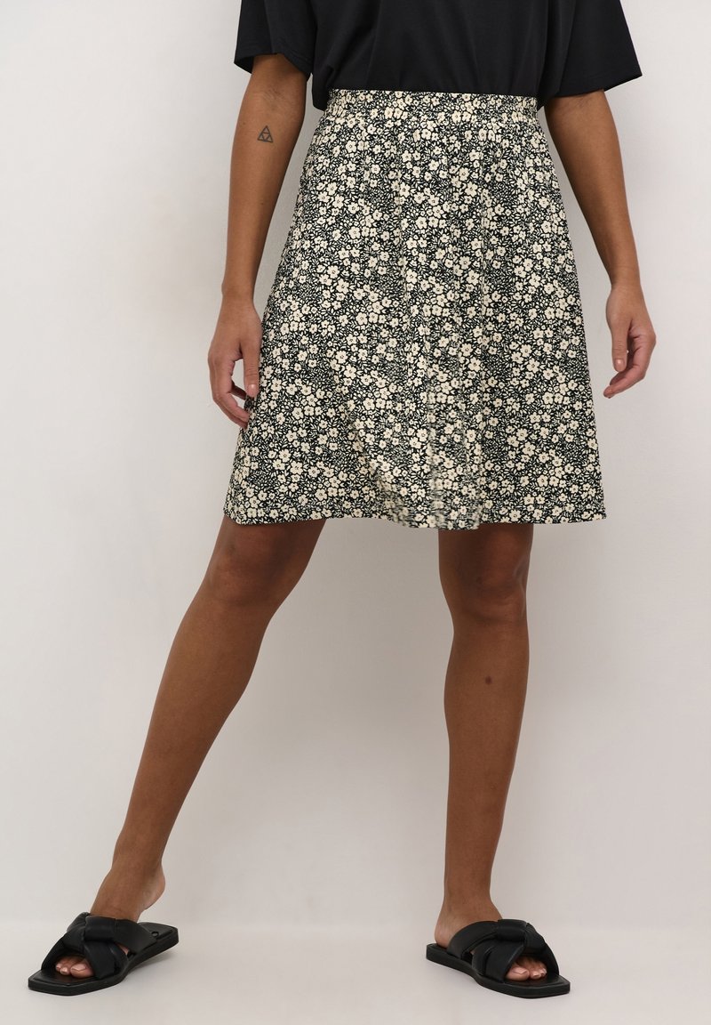 Gonna nera floreale con silhouette svasata, tessuto leggero, piccoli motivi a fiori bianchi e cintura elastica per il massimo comfort.