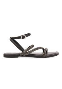Sandalias planas negras con correas de cuentas, que cuentan con un cierre de tobillo seguro. La suela es lisa y el diseño es minimalista y con la punta abierta.