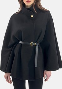 Mantella nera in lana con colletto alto, caratterizzata da un bottone dorato e una cintura nera con fibbia dorata, tessuto testurizzato e silhouette fluente.