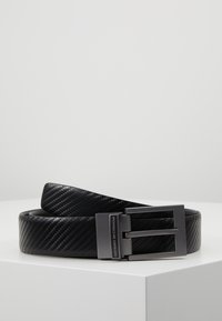 Ceinture noire en matériau texturé, présentant une finition lisse, une boucle élégante de teinte argentée et un discret logo.