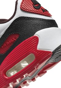 Nike Air Max tenisice s gornjim dijelom od crne kože, crvenim akcentima, bijelim međuslojem i vidljivom zračnom jedinicom. Teksturirani uzorci poboljšavaju prianjanje i dizajn.
