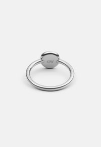 Anello d'argento con una parte superiore rotonda e liscia e una banda sottile. Presenta le iniziali incise "MD" sul lato interno. Finitura riflettente e design minimalista.
