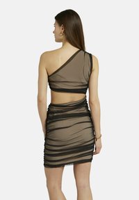 Ein schulterfreies Kleid aus durchsichtigem braunen Material mit schwarzen Akzenten, das über geraffte Texturen und einen offenen Rücken verfügt.