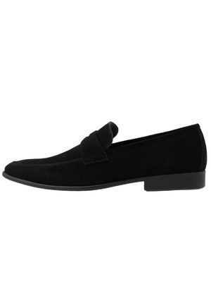 Mocassin pour homme en daim noir avec un petit talon et une couture de style mocassin à l'avant, design à enfiler avec une bride sur le dessus.