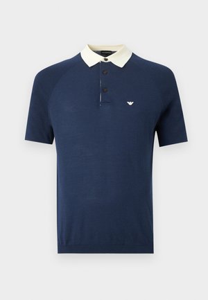 Tengerészkék rövid ujjú galléros póló fehér gallérral, három fekete gombbal és kis fehér logóval a bal mellrészen.