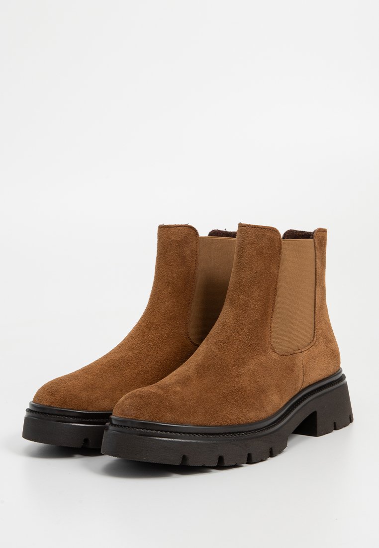 Braune Wildleder-Ankle-Boots verfügen über elastische Seiteneinsätze, eine stabile schwarze Gummisohle und ein abgerundetes Zehendesign.