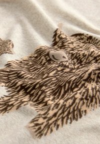 Tissu beige avec un motif animal brun, présentant une texture de fourrure détaillée et des dégradés subtils. Le design met en valeur les caractéristiques réalistes de l'animal.