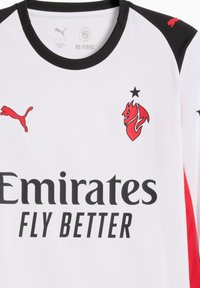Hvid sportstrøje med sorte kanter. Har et rødt logo på venstre bryst, sorte stjerner og sort tekst: "Emirates FLY BETTER."