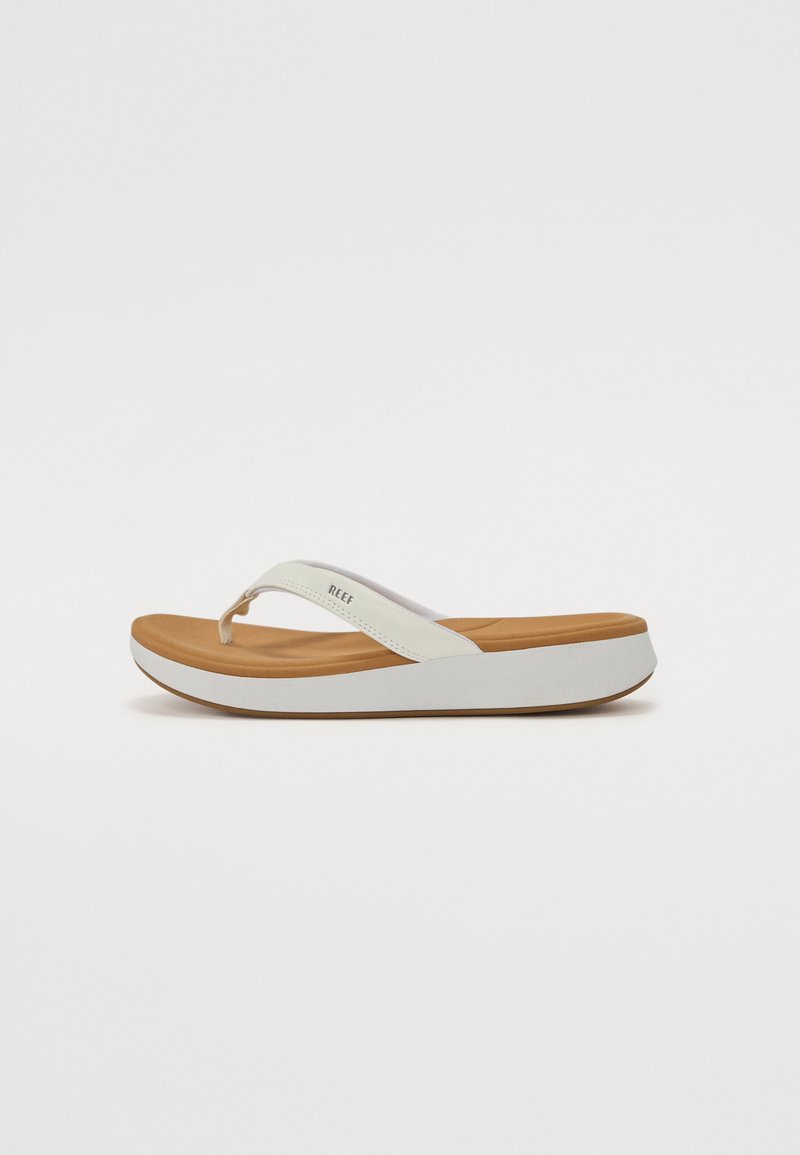 White flip-flop sandal with textured straps, cushioned tan footbed, and contrasting white sole. Features a sleek, minimalist design.
