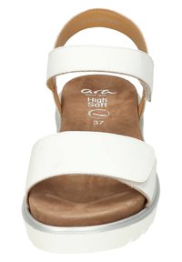 Weiße Leder-Plateausandalen mit zwei breiten Riemen, einer weichen braunen Innensohle und einem leichten Absatz. Sie besitzen eine glatte Textur und dezente silberne Akzente.