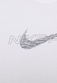 White cotton t-shirt featuring a black graphic design of the "Nike" logo with dynamic lines and a swoosh accent. Smooth texture.