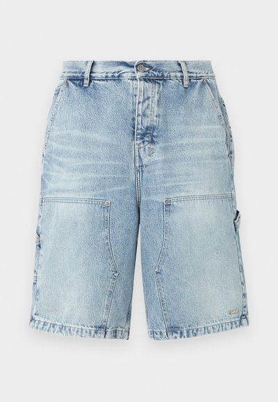 Vaaleansiniset farkkushortsit, joissa on rento leikkaus, ja joissa on kaksi etutaskua sekä lisätaskut sivuilla. Koko vaatteessa on kulutettu pinta.