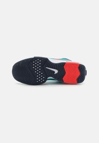 Sportieve schoenzool van zwart rubber met rode en witte accenten. Beschikt over een gestructureerd loopvlak en een glad logo in het midden.