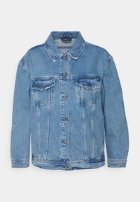 Veste en denim bleu clair avec fermeture à boutons, deux poches poitrine et un col classique. Présente des surpiqures doubles et une texture légèrement décolorée.