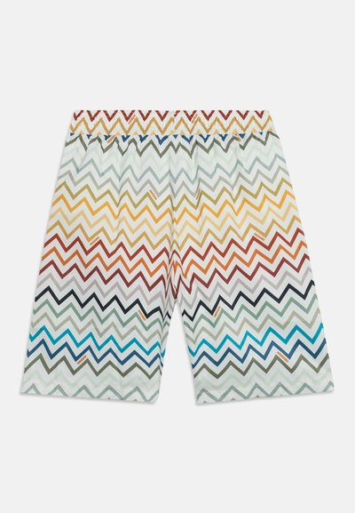 Short blanc court avec des motifs zigzag multicolores dans des tons de bleu, vert, orange, rouge et jaune, vu de dos.