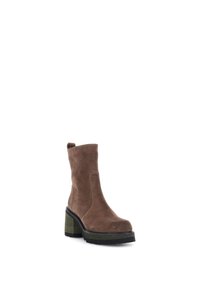Bottine en daim marron avec un talon épais aux accents verts, texture lisse et une languette pour un enfilage facile.