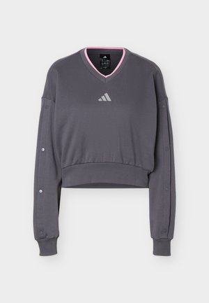 Σκούρο γκρι κοντομάνικο φούτερ με V λαιμόκοψη με ροζ περιθώριο, κουμπιά πάνας κατά μήκος των μανικιών, ριμπ περιλαίμια και κεντρικό αντανακλαστικό λογότυπο Adidas.