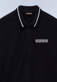 Čierna polo košeľa má klasický dizajn s troj-gombíkovým zapínaním, kontrastnými bielymi pruhmi na golieri a vyšívaným logom.