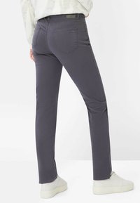 Grå bukser i bomuldsblanding med tætsiddende pasform, fem lommer og diskrete syningsdetaljer. Bruges med lyse sneakers.