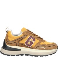 Herrenschuhe mit einem Obermaterial aus gelbem Netzstoff, braunen Wildlederakzenten, schwarzer Gummisohle und einem maroonfarbigen "G"-Logo an der Seite.