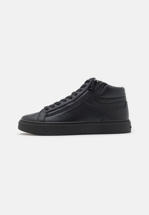 Black leather high-top sneaker with side zipper, laces, and thick rubber sole on a plain white background.