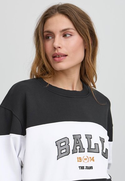 Sudadera en blanco y negro con cuello redondo, diseño a bloques de color y letras grandes con "BALL 1914 THE JEANS" en gris y naranja.