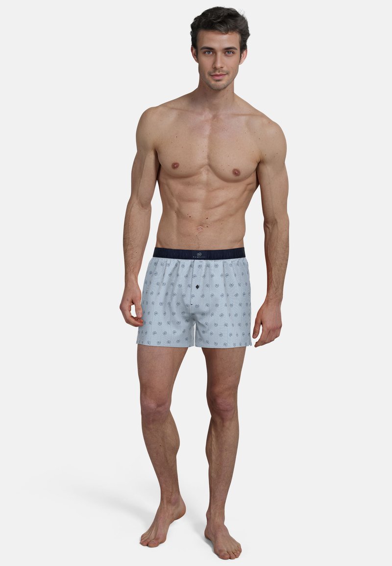 Blue and white striped boxers with a navy elastic waistband, featuring a pattern of small circles and a relaxed fit. Cotton material.