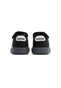 Svarta sneakers med en slät yta, rund tå, platt sula och framträdande logotyp på hälen. Snörning och mjuk vadderad krage ingår.