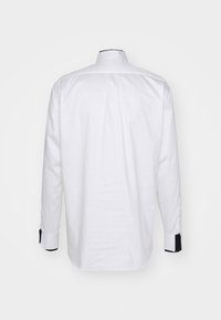 Weißes Langarmhemd mit schwarzem Besatz am Kragen und an den Manschetten, mit glatter Textur und klassischem Schnitt.