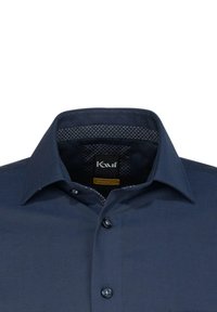 Camicia blu navy con bottoni, dal taglio moderno, caratterizzata da una fodera del colletto testurizzata e accenti di bottoni a contrasto. Il materiale appare liscio.