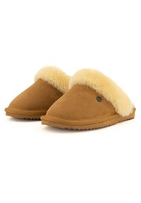 Kastanjebruine suède sloffen met een zachte crème schapenvacht manchet, ronde neus en een getextureerde rubberen zool voor grip. Eenvoudig ontwerp, minimale details.
