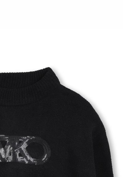 Pull en tricot noir avec un col rond côtelé, présentant un logo en sequins brillant au centre. Texture douce, coupe décontractée.