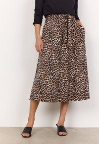Jupe imprimé léopard aux nuances de marron et de noir, dotée d'une taille nouée, de poches latérales et d'une coupe fluide à mi-longueur.