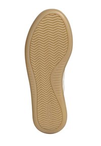 Suela de zapatilla de goma con un patrón texturizado en beige, que presenta un diseño ondulado y en zigzag, con el logotipo de "adidas".