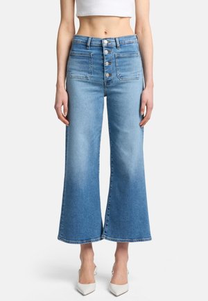 Lyseblå vide jeans laget av denim, med høy midje, fem-knappers lukking og standard baklommer med falmønster.