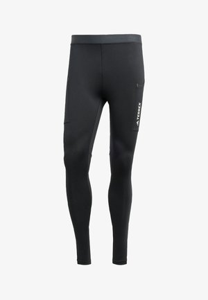 Zwarte sportleggins gemaakt van een gladde, rekbare stof. Kenmerken zijn een zijzak en een logo op de dij.