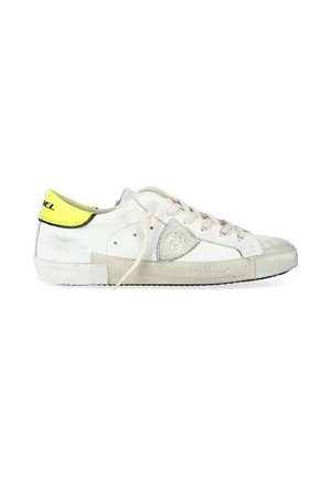Sneaker bassa bianca con suola beige, lacci beige, punta in suede grigia e linguetta del tallone gialla neon con rifiniture e testo neri.