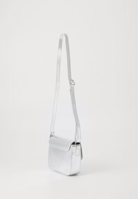 Stříbrná metalická crossbody taška s obdélníkovým tvarem, hladkým povrchem, nastavitelým popruhem a klopovým uzávěrem, která vystihuje minimalistický design.