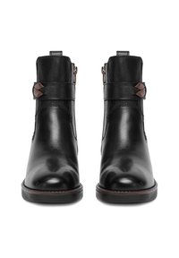 Botines de cuero negro con acabado liso, que cuentan con cremalleras laterales, una correa de acento marrón y una punta redondeada. Suela plana y duradera.
