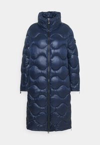 Marinblå lång pufferjacka med vågig kviltad design, hög krage, framdragkedja och långa ärmar med dragkedjefästen.