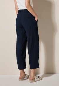 Marina rippade byxor med avslappnad passform, med sidofickor och hög midja. Tyget har en strukturerad yta.