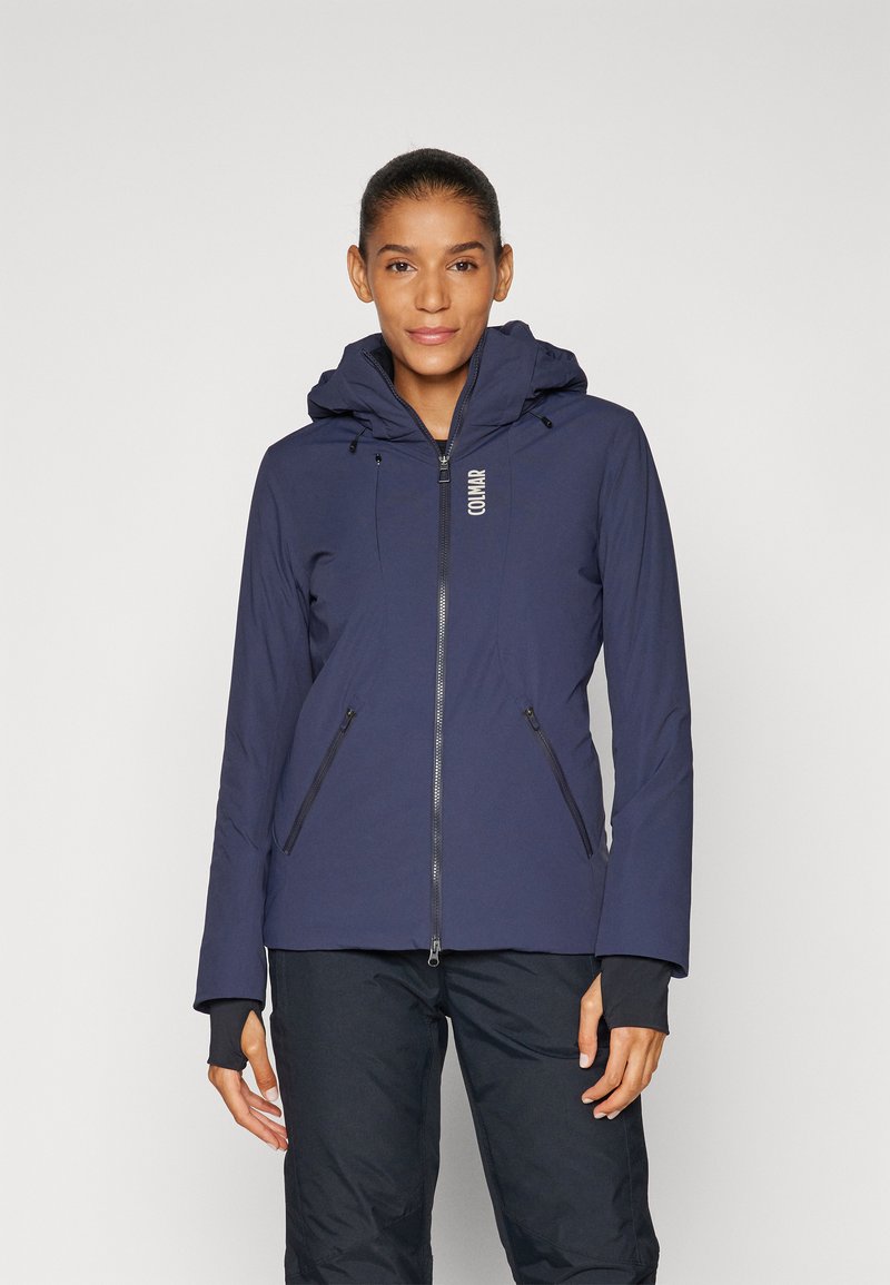 Navy blue jacket with a zip front, two side pockets, and an adjustable hood. Features long sleeves and contrasting cuffs.