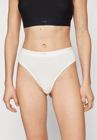 Witte vrouwenonderbroek met een gladde textuur, hoge snit en zachte tailleband met een subtiele logo. Eenvoudige, klassieke stijl.