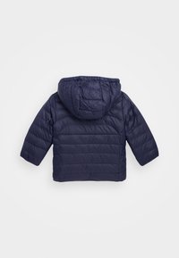 Námorně modrá prošívaná bunda s kapucí a dlouhými rukávy, zobrazená zezadu na jednolitém světlém pozadí.